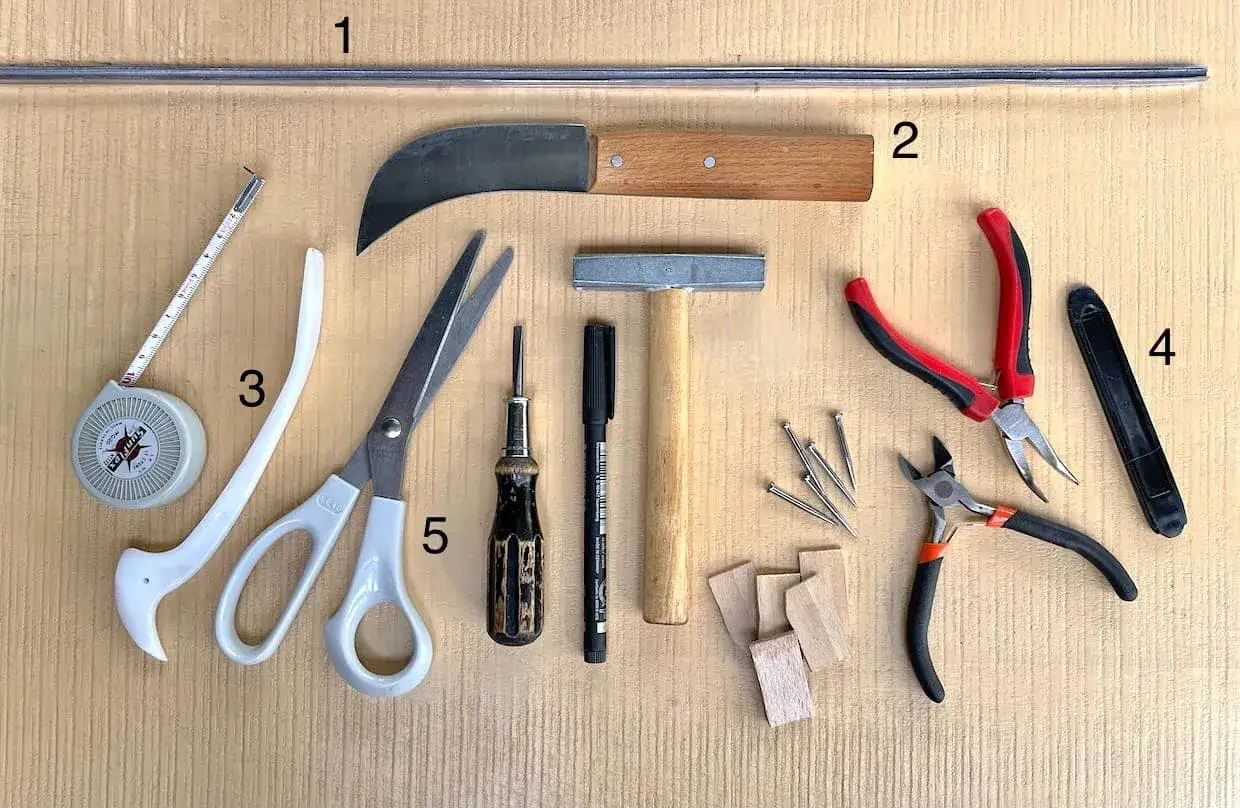 Outils pour devenir vitrailliste : ruban &agrave; mesurer, couteau, ciseaux, marteau, pinces, clous, etc.