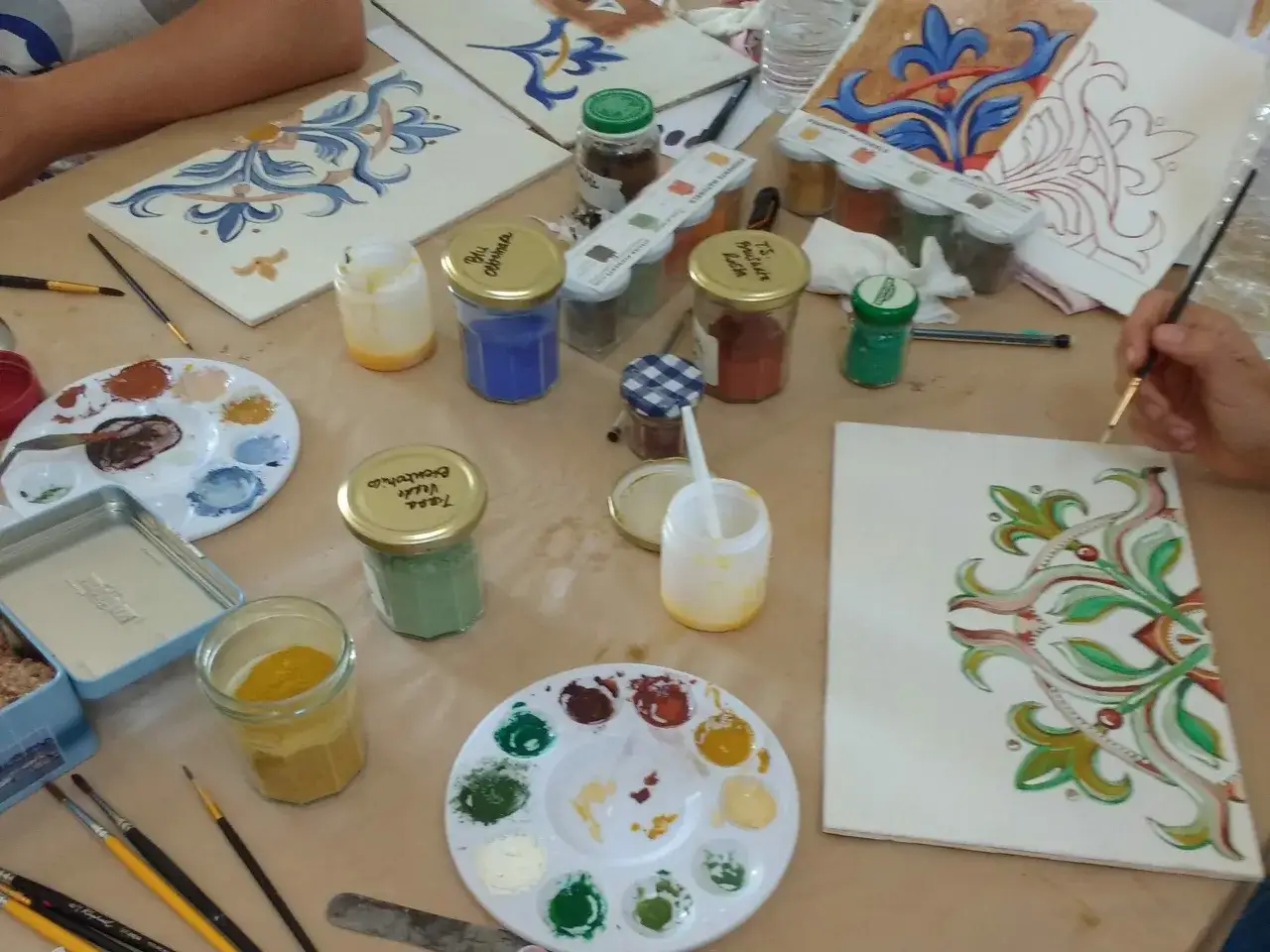 Atelier de peinture sur c&eacute;ramique avec pigments naturels. Une recette de colle naturelle est peut-&ecirc;tre en cours de pr&eacute;paration pour fixer les couleurs.