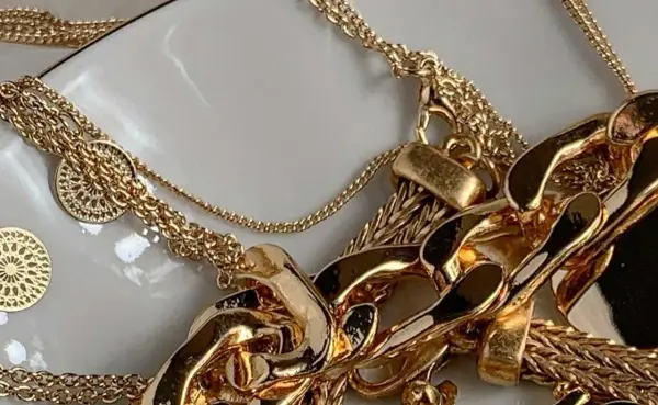 Un bain d'or pour bijoux : des chaînes épaisses et fines, des pendentifs ronds ajourés, un amas de luxe scintillant.