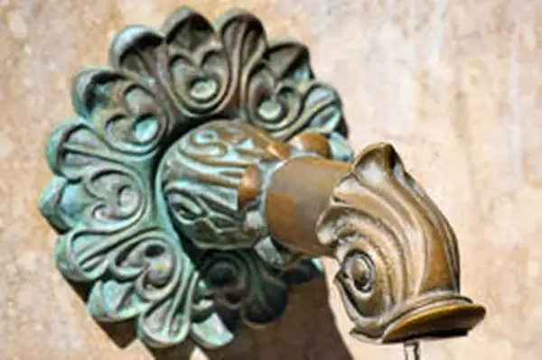Robinet en laiton orné, avec des traces de vert-de-gris.