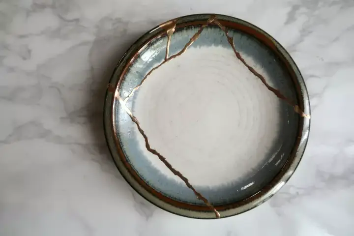 Une assiette ébréchée, réparée avec de l'or, témoigne de la beauté de la résilience.