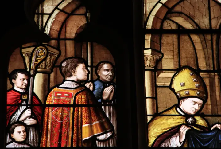 Vitraux de la cathédrale de Nevers : scènes religieuses avec des personnages en habits liturgiques, un évêque coiffé de sa mitre dorée.
