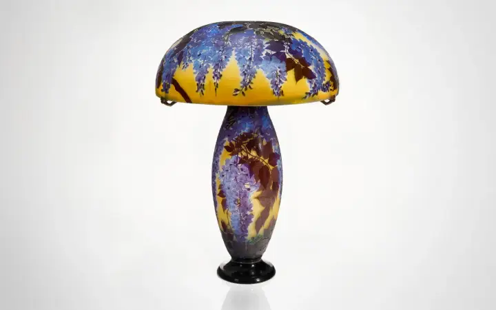 Lampe Art Nouveau d'un artiste verrier, ornée de glycines bleues et de feuilles sur un fond jaune.